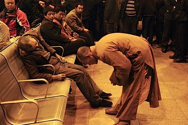 The humble actions of a monk at a train station in China captivated the world. The monk bows to the deceased in respect. He holds his hand to comfort him (feature picture top).