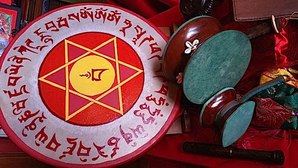 Three types of drum in the author's collection: left to right - hoop drum with custom mantra design (from Gaia Workshops https://gaiasworkshop.com) and tradition Chod drum and smaller traditional Damaru drum.