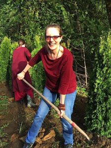 Lama Acharya Dr. Shannon Young planting a tree at a retreat centre.