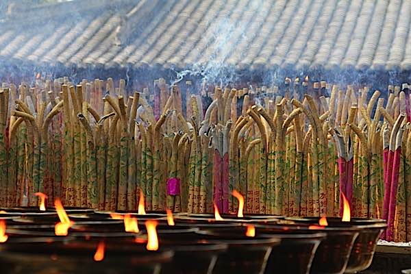 Buddha Weekly light and incense candles and joss sticks at Buddhist temple Buddhism