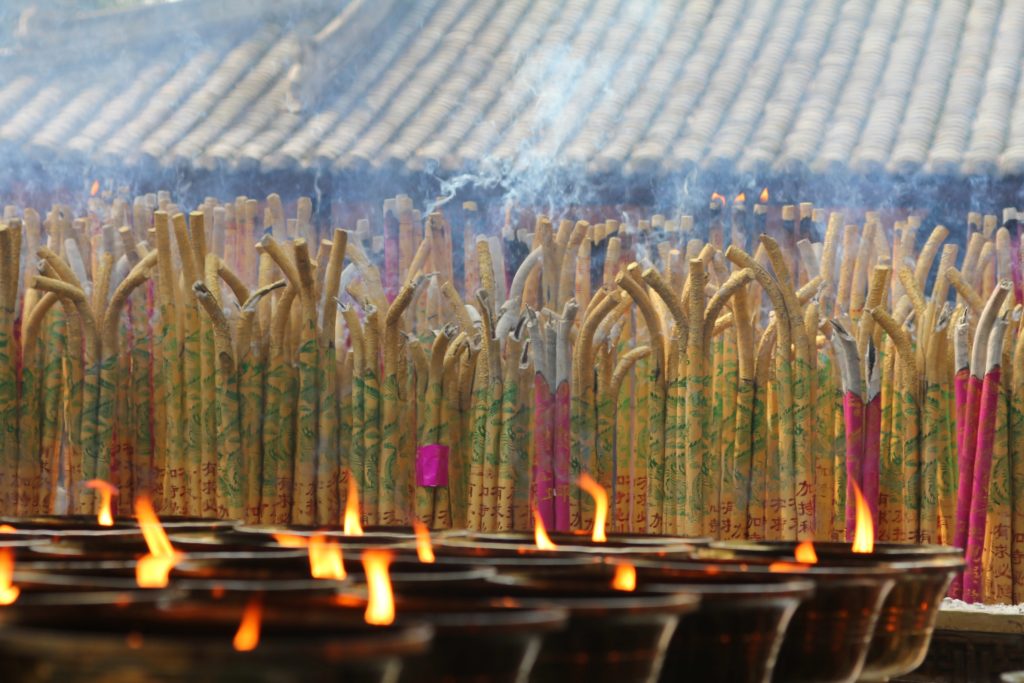 light and incense candles and joss sticks at Buddhist temple Buddha Weekly Buddhist Practices