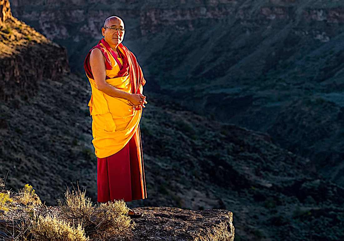 Buddha Weekly Geshe Sherab on cliff in mountains Buddhism