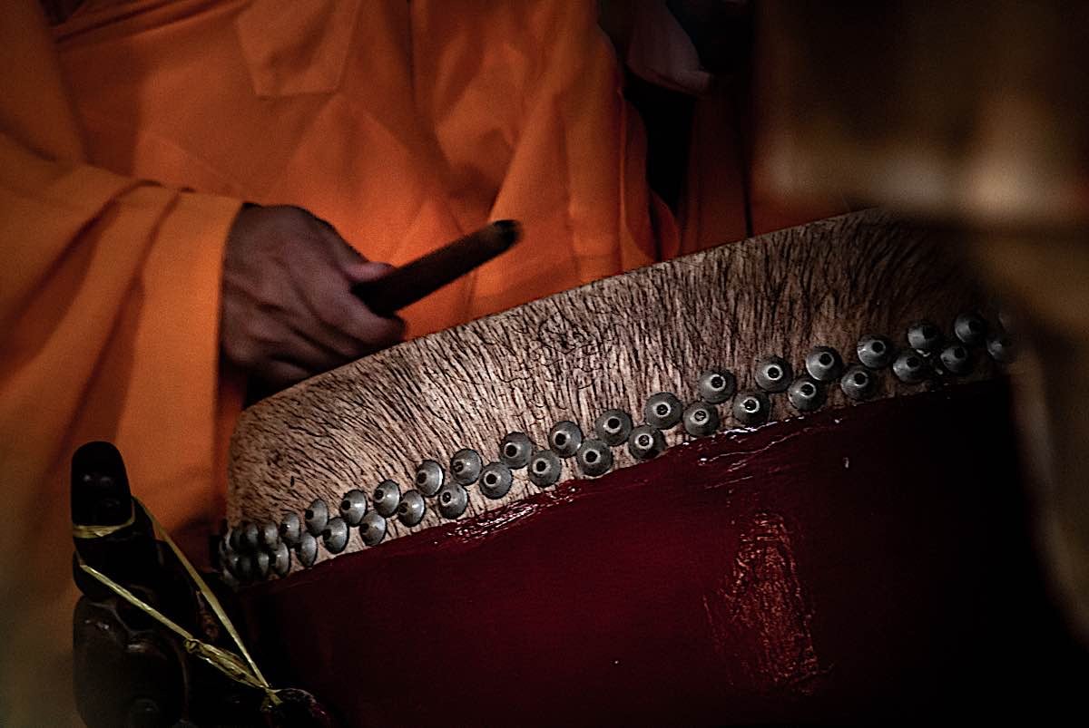 Buddha Weekly Monk plays drum in temple during prayers meditation dreamstime l 157029143 Buddhism