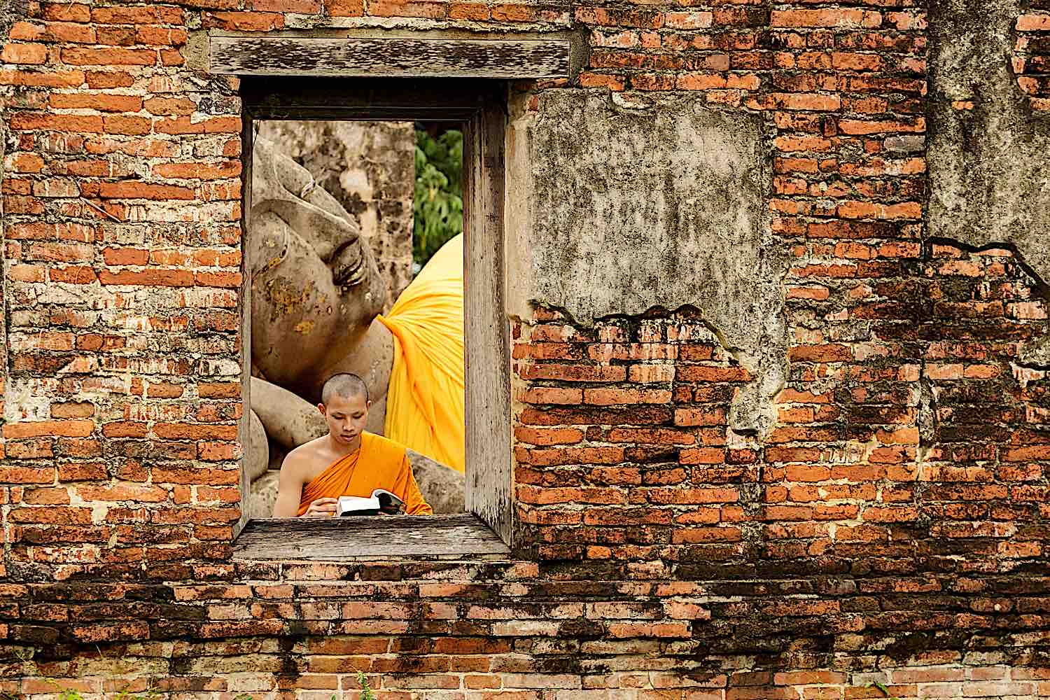 Buddha Weekly Monk reading a book in front of Reclining Buddha dreamstime 60522913 Buddhism