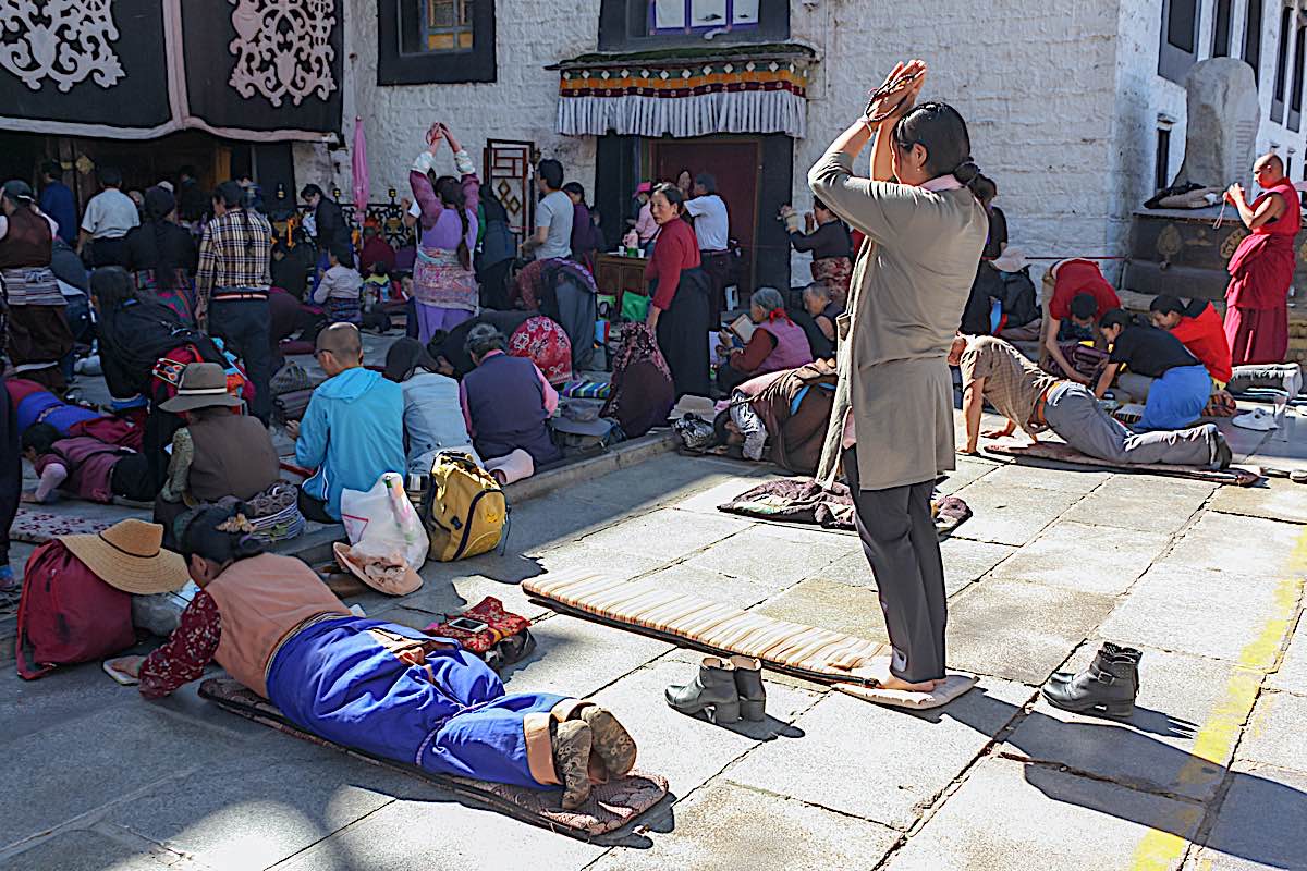 Buddha Weekly People praying in prostration in front of Jokhang temple in Lhasa on Barkhor square Tibet one woman standing dreamstime xxl 186290034 Buddhism