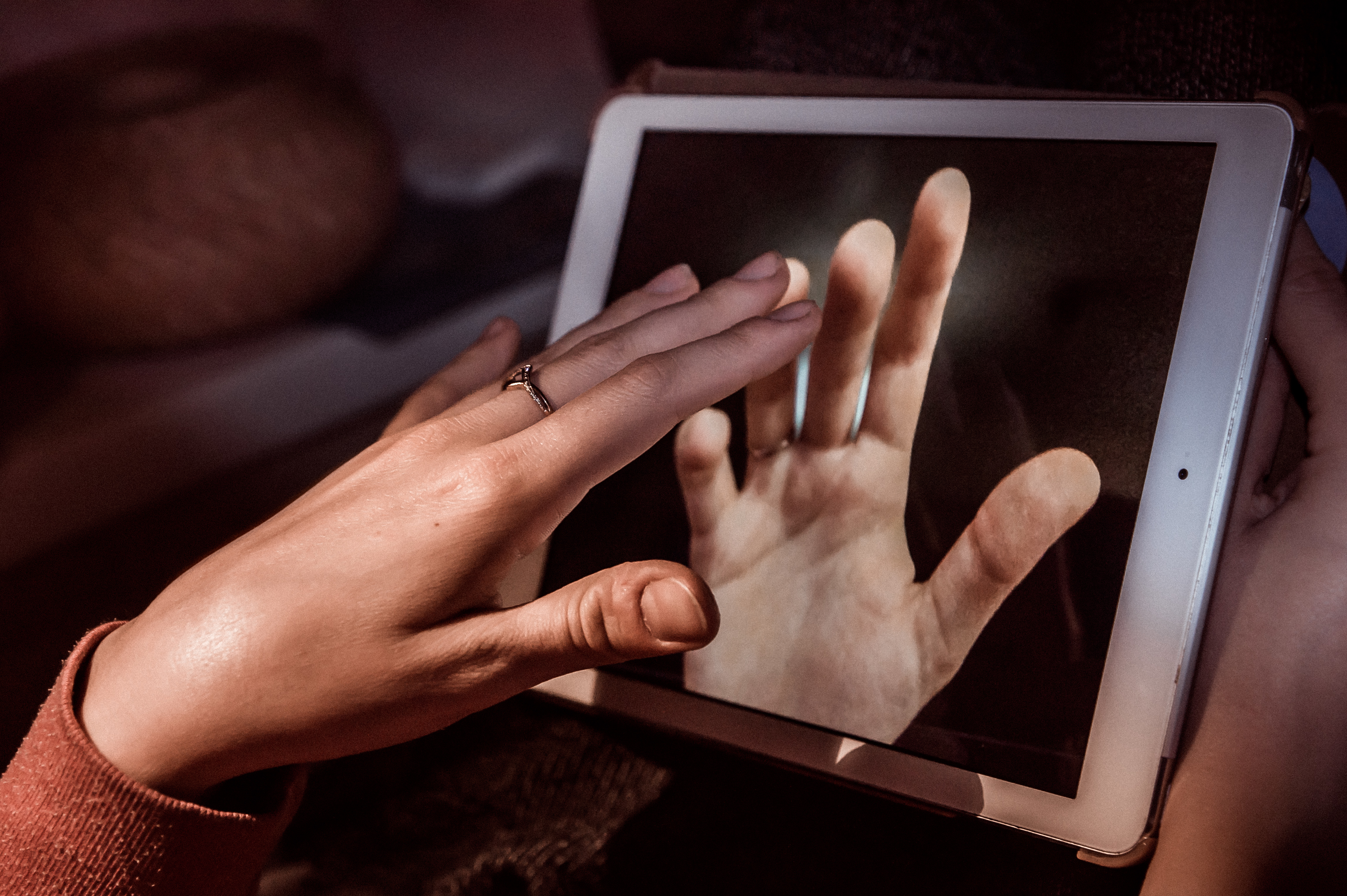 Long distance relationship hands touching through ipad