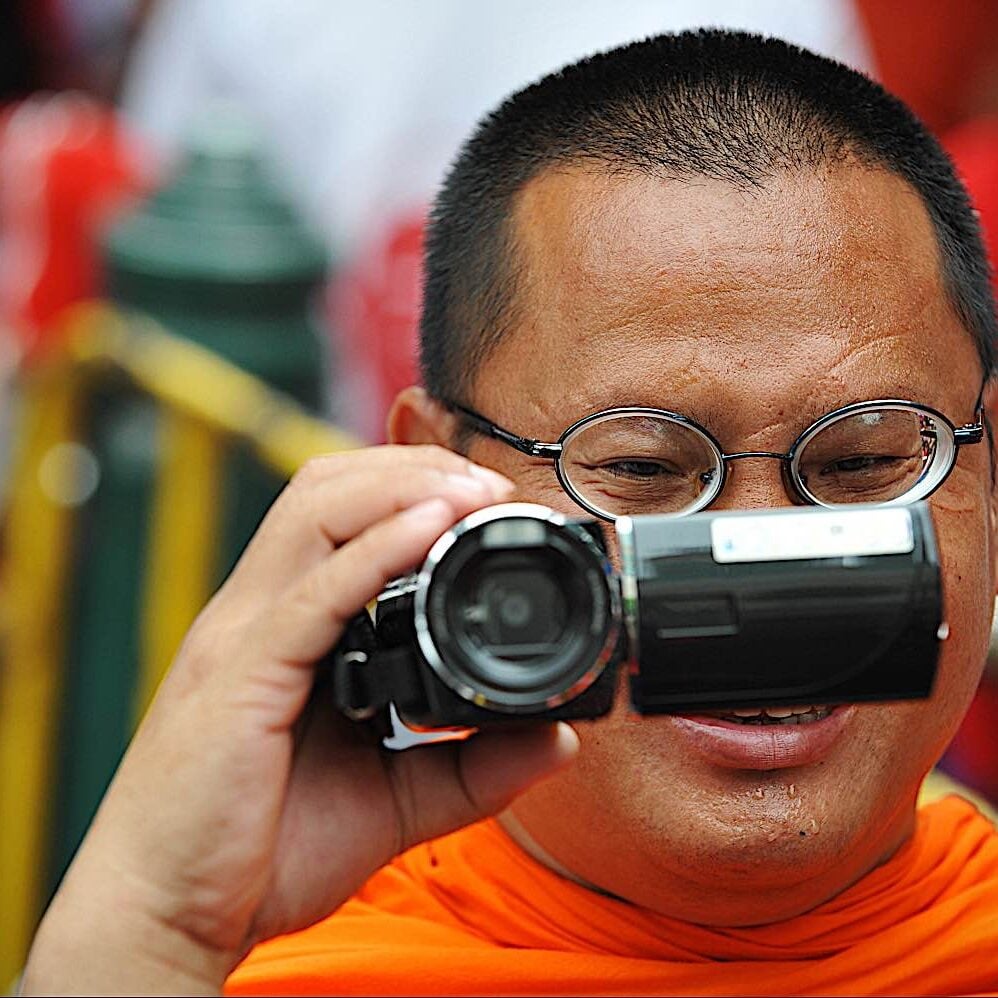 Buddha-Weekly-Buddhist monk with camcorder dreamstime_l_49495638-Buddhism