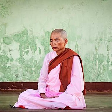 A Buddhist nun meditating during full moon festival at Shwedagon Pagoda. In Buddhism, women are the equal of men in their ability to achieve spiritual attainments.