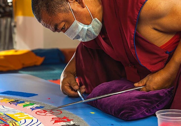 Buddha-Weekly-Kalachakra sand mandala monks dreamstime_66831866-Buddhism At major Kalachakra events, monks usually create elaborate and beautiful impermanent sand mandalas — one spec of colored sand at a time. After the beautiful work of art is completed and dedicated, it is swept away to show impermanance.