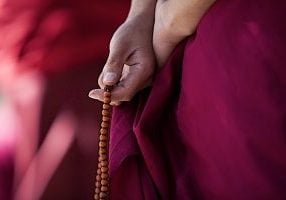 Chanting mantras with a mala. Mantras are an accumulation merit practice. Chanting once of twice will have limited results. For best results, we grow merit through regular mantra sessions, practicing with Bodhichitta and compassion, and with faith.