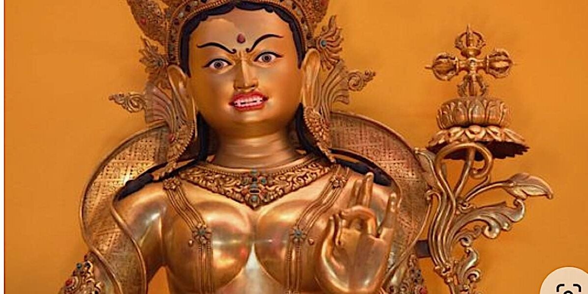A statue of Tara. Notice she is holding her uptala flower in her left hand (which is in the mudra of Taking Refuge in the Three Jewels) — and on the top of the flower blosum is a double vajra — the cosmic mandala symbol of Tara's Karma family. This is the symbol representing both Tara and her co-equal consort Amoghasiddhi.