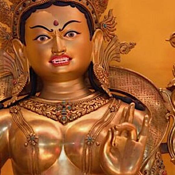 A statue of Tara. Notice she is holding her uptala flower in her left hand (which is in the mudra of Taking Refuge in the Three Jewels) — and on the top of the flower blosum is a double vajra — the cosmic mandala symbol of Tara's Karma family. This is the symbol representing both Tara and her co-equal consort Amoghasiddhi.