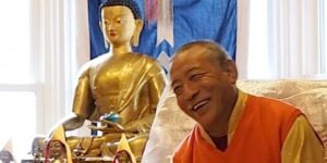 Buddha Weekly Zasep Tulku Rinpoche laughing at Gaden Choling in front of altar Buddhism custom crop