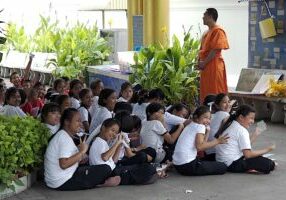 A monk teaching school children at Wat Temple Saraburi Thailand.